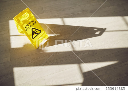 Wet Floor sign on clean freshly mopped slippery grey floor with sunlight and shadows 133914885