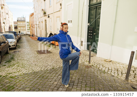 Dynamic performer on city street showcasing expressive dance movements 133915457