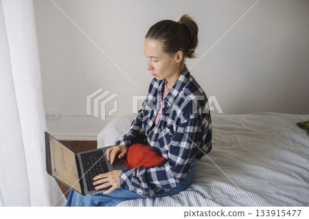 Woman shopping comfortably, Woman reviews products while lounging Woman shopping comfortably, Woman reviews products while lounging 133915477
