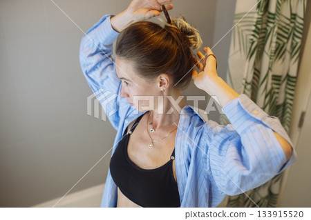 Woman adjusting hairstyle and outfit prior to dance rehearsal 133915520
