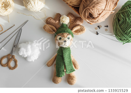 Crocheted Reindeer Toy with Yarn and Crafting Tools in Cozy Workspace Crocheted Reindeer Toy with Yarn and Crafting Tools in Cozy Workspace 133915529