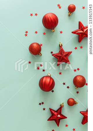 Red Christmas Ornaments and Confetti on Light Blue Background Red Christmas Ornaments and Confetti on Light Blue Background 133915543