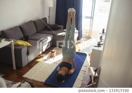 caucasian woman practicing shoulderstand progression at home caucasian woman practicing shoulderstand progression at home 133915590