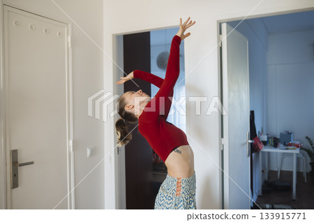 Woman with long sleeves poses with determination and poise Woman with long sleeves poses with determination and poise 133915771
