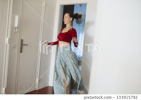 Lively woman performing vibrant spinning dance in sunlight Lively woman performing vibrant spinning dance in sunlight 133915792