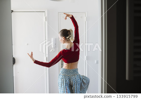 Elegant dance stance, Graceful dancer with extended arms and sleek line 133915799