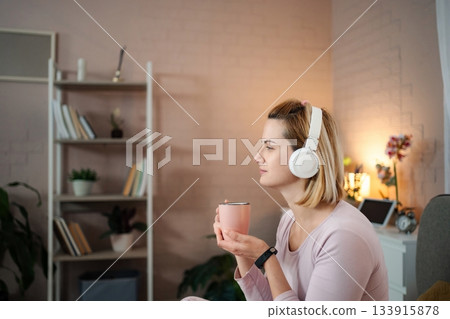 Woman listening to music and relaxing at home 133915878