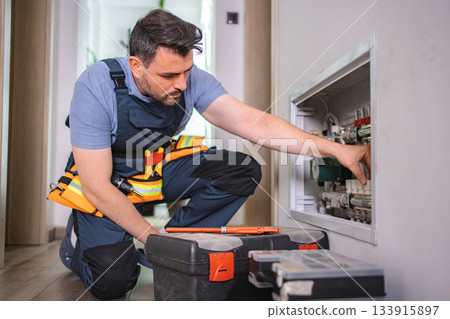Plumber fixing pipes and valves of heating system in a residential building Plumber fixing pipes and valves of heating system in a residential building 133915897