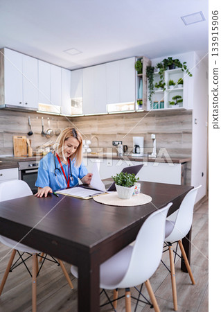 Female Doctor Working From Home in her Kitchen Female Doctor Working From Home in her Kitchen 133915906