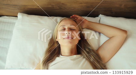 Woman sleeping lying in bed on white soft comfortable pillow in bedroom at home Woman sleeping lying in bed on white soft comfortable pillow in bedroom at home 133915929