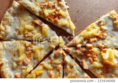 Delicious slices of pizza with chicken and pineapple on a sunny day 133916006