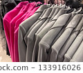 Stylish gray and pink garments hanging on display in a chic retail store 133916026