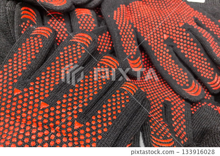 Brightly colored safety gloves stacked for easy access at a worksite Brightly colored safety gloves stacked for easy access at a worksite 133916028
