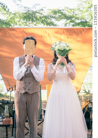 Wedding photo of the bride and groom standing together at a campsite with their faces hidden Wedding photo of the bride and groom standing together at a campsite with their faces hidden 133916305