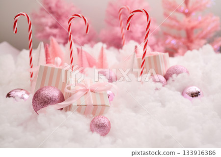 Pink Winter Wonderland. A festive scene with pink trees, gifts, and candy canes Pink Winter Wonderland. A festive scene with pink trees, gifts, and candy canes 133916386
