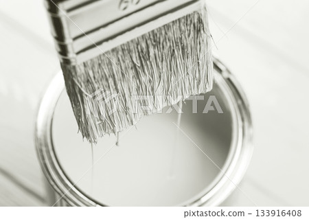 Paintbrush dripping paint into open can in monochrome. Color of 2026 year dancer in the white cloud 133916408