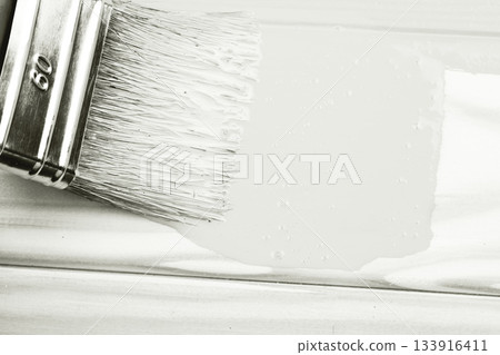 Paintbrush applying white paint to wooden surface. Color of 2026 year dancer in the white cloud 133916411