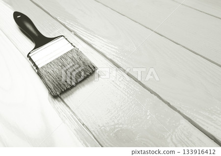 Paintbrush applying white paint to wooden boards. Color of 2026 year dancer in the white cloud Paintbrush applying white paint to wooden boards. Color of 2026 year dancer in the white cloud 133916412