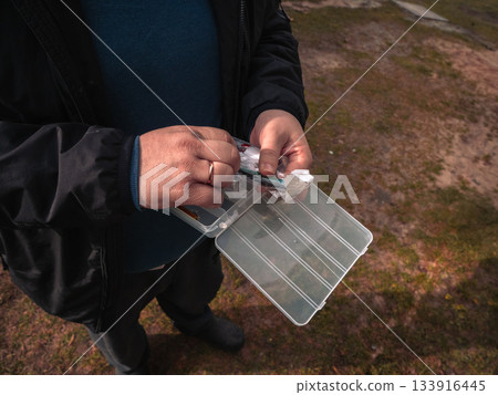 Setting out baits until early morning. Preparing various fishing lures and tackle for the early morning fishing. Laying out multicolored fishing wobblers and lures for the early morning fishing. Setting out baits until early morning. Preparing various fishing lures and tackle for the early morning fishing. Laying out multicolored fishing wobblers and lures for the early morning fishing. 133916445