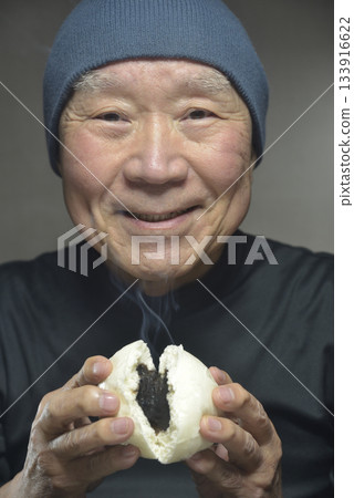 An elderly man eating steaming bean-jam buns with a smile An elderly man eating steaming bean-jam buns with a smile 133916622