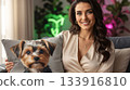 The image shows a woman holding a throw pillow with a Yorkshire Terrier on it 133916810