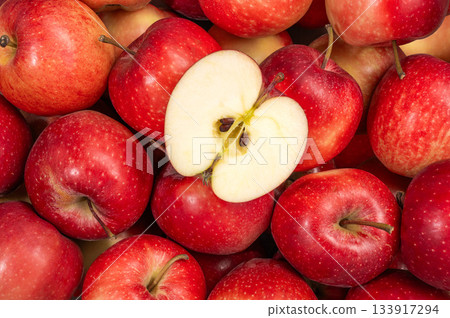 A group of red gala apples viewed from above with a slice cut into the center 133917294