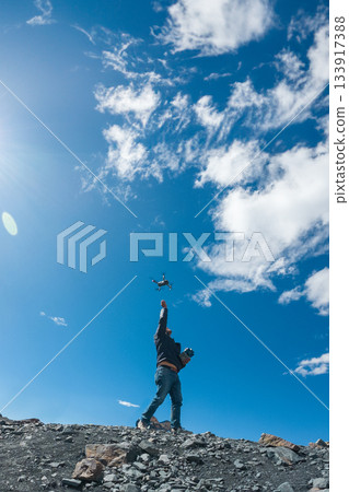 A man is flying a drone in the sky 133917388
