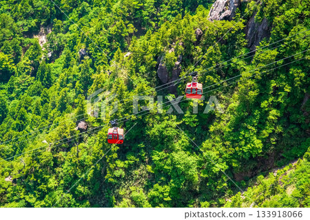 A red gondola passing in front of the Fujimiiwa Observatory on the Gozaisho Ropeway (Komono Town, Mie Prefecture) A red gondola passing in front of the Fujimiiwa Observatory on the Gozaisho Ropeway (Komono Town, Mie Prefecture) 133918066