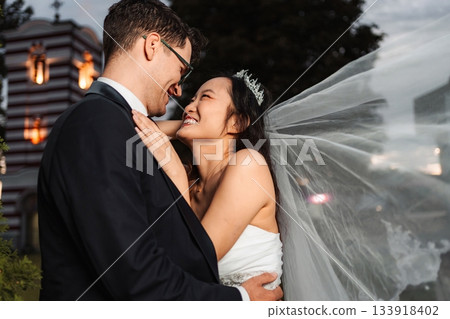 Interracial couple embracing during wedding day Interracial couple embracing during wedding day 133918402