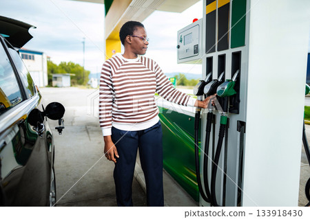 African american woman fueling car at gas station 133918430