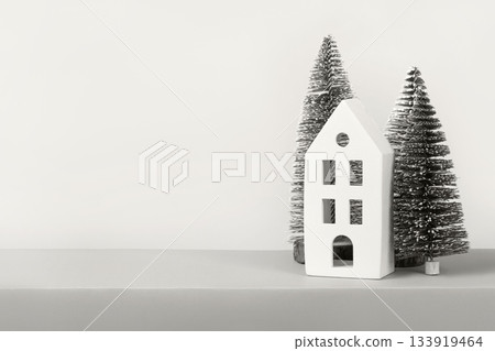 Demonstrating the colors of 2026 - Cloud Dancer. Christmas winter card with trees and a white house with space for text, greetings, promotions, and discounts. 133919464