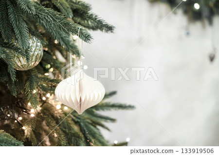 Christmas tree decorating with a white paper ornament. Color of 2026 year dancer in the white cloud Christmas tree decorating with a white paper ornament. Color of 2026 year dancer in the white cloud 133919506