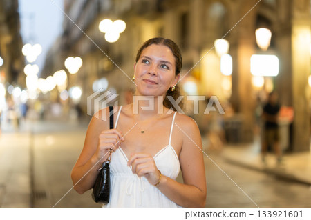 In night, young smiling girl walks along city street Ferran 133921601