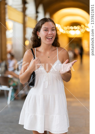 young woman walks through the evening streets of Barcelona 133921651