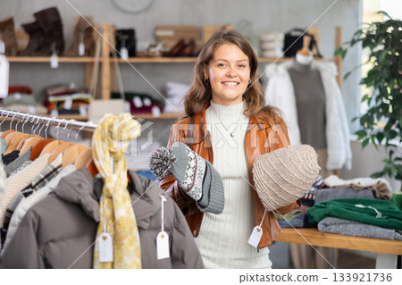 Female shopper chooses a hat in clothing store 133921736