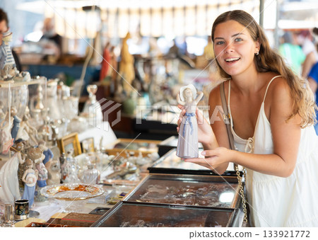 Female traveler buyer chooses ceramic antiquarian porcelain shepherdess 133921772