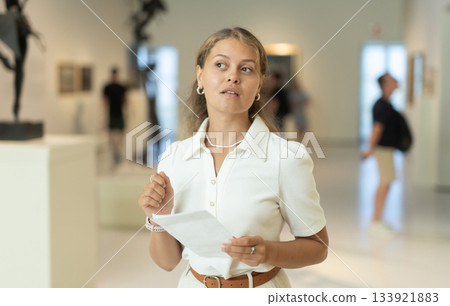 Girl walks around museum hall, view exhibition items Girl walks around museum hall, view exhibition items 133921883