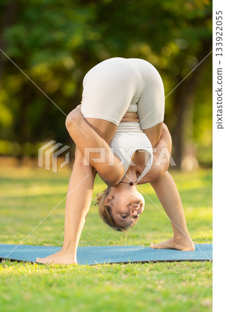 Girl enjoying outdoor yoga practice in green summer park Girl enjoying outdoor yoga practice in green summer park 133922055