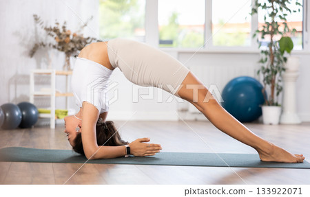 Fit young woman doing pilates yoga exercise fitness training workout. Physical activity for body and mind relaxation, healthy lifestyle habits concept Fit young woman doing pilates yoga exercise fitness training workout. Physical activity for body and mind relaxation, healthy lifestyle habits concept 133922071