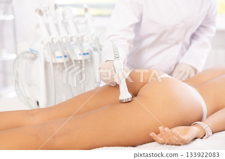 Woman undergoing high-frequency ultrasound procedure on buttocks in cosmetic clinic Woman undergoing high-frequency ultrasound procedure on buttocks in cosmetic clinic 133922083