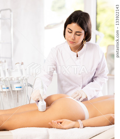 female doctor making hip beauty procedure with ice hummer female doctor making hip beauty procedure with ice hummer 133922143