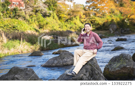 一位男士在河邊放鬆。 一位男士在河邊放鬆。 133922275