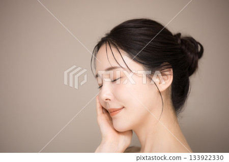 An image of a beautiful woman with her hair up and a beige background, easy to use for beauty and skin care, eyes closed An image of a beautiful woman with her hair up and a beige background, easy to use for beauty and skin care, eyes closed 133922330