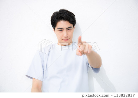 A refreshing man in short sleeves on a white background, pointing at the camera A refreshing man in short sleeves on a white background, pointing at the camera 133922937
