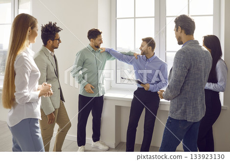 Group of business people chatting after a meeting. Company employees talking in the office. Group of business people chatting after a meeting. Company employees talking in the office. 133923130