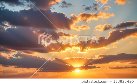 This is an image showcasing a dramatic sunset with a dark cloudy sky transitioning to warm hues as the sun dips below the horizon 133923480