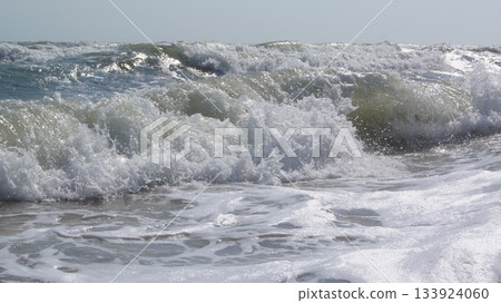 Storm at sea. Foaming seawater from raging waves. A dangerous storm at sea. A beautiful and dangerous element.  133924060