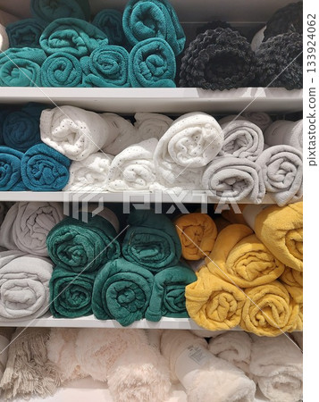 Multi-colored soft fleece blankets are neatly folded on shelves in a store. Fleece blankets. Multi-colored soft fleece blankets are neatly folded on shelves in a store. Fleece blankets. 133924062