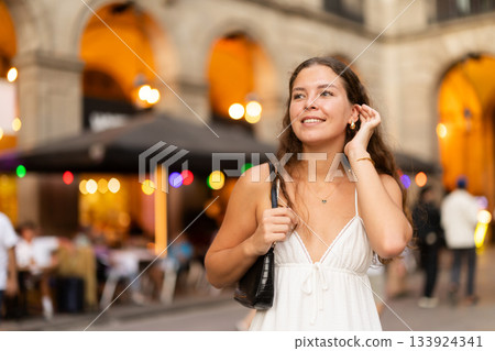 young woman walks through the evening streets of Barcelona young woman walks through the evening streets of Barcelona 133924341