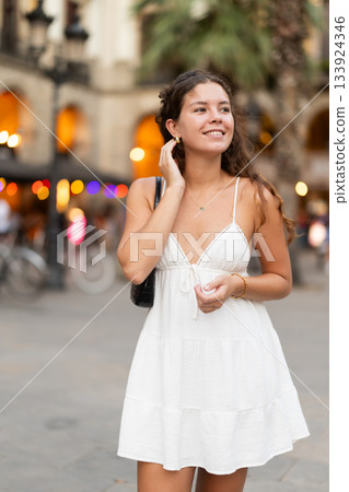 young woman walks through the evening streets of Barcelona young woman walks through the evening streets of Barcelona 133924346